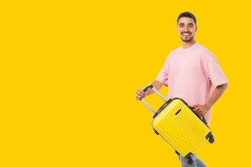 Man smiles while holding a bright suitcase ready for adventure