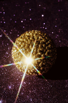 Shiny Golden Decorative Sphere on a Glittering Surface