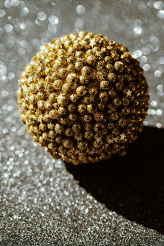 Shiny Gold Ornament on Shimmering Surface for Festive Decor