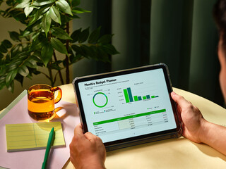 Someone is analyzing their finances using a tablet to review plan