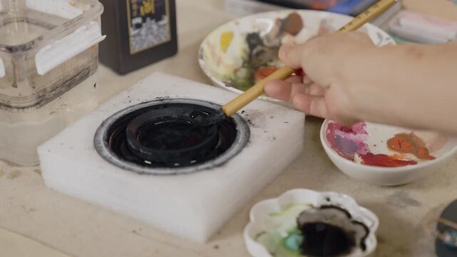 Artist Painting Workspace with Watercolor Ink and Brushes