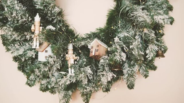 Frosted evergreen wreath with nutcracker figures and tiny houses