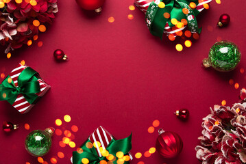 Merry Christmas and Happy Holidays greeting card, frame, border. New Year. Red Christmas ornaments and gifts, presents on red background top view. Xmas holiday festive theme. Christmas decoration