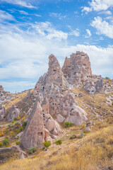 A stunning vertical landscape of Cappadocia, Turkey, showcasing its iconic fairy chimney rock formations and ancient cave dwellings carved into soft volcanic stone