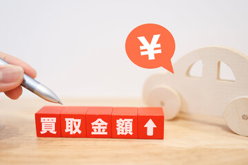 車の買取金額アップを示すブロックと円マーク。