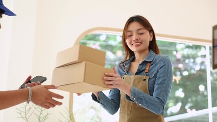 Deliveryman confirming parcel with cafe owner woman using smartphone, representing digital signature, cashless payment, efficient collaboration between delivery service and small business logistics