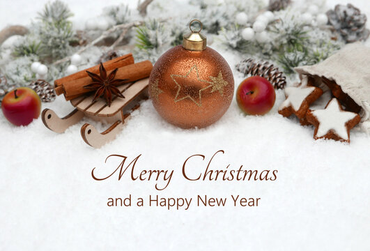 Christmas card: Christmas ornaments with cookies, apple, cinnamon stick and fir branches on a wintery background with the text Merry Christmas and a Happy New Year. - Powered by Adobe