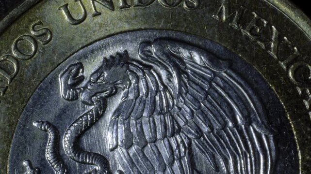 Close-up of Mexican coin showing eagle and snake with detailed engraving