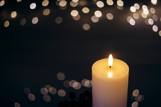 Advent white candle with decor in shiny lights closeup - Powered by Adobe