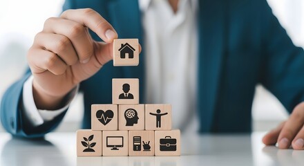 Person arranging wooden blocks with icons for home, health and career, symbolizing comprehensive life planning.