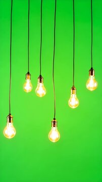 Seven illuminated lightbulbs hang vertically against a vibrant green screen studio backdrop.