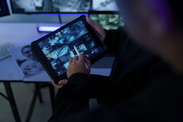 Focus on the security guard's hand checking the CCTV camera screen.