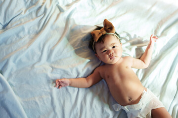 A newborn baby sleeps happily in a holiday bedroom.