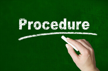 Person writing a Procedure word with chalk on a classroom style blackboard