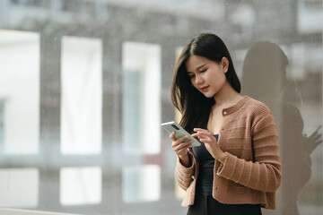 Beautiful Asian woman checking social media chatting on smartphone lifestyle outdoor