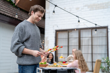 Multiracial family having fun and enjoying party outdoors in garden.