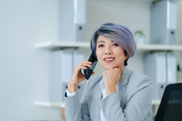 Asian senior businesswoman work talking on phone in office room