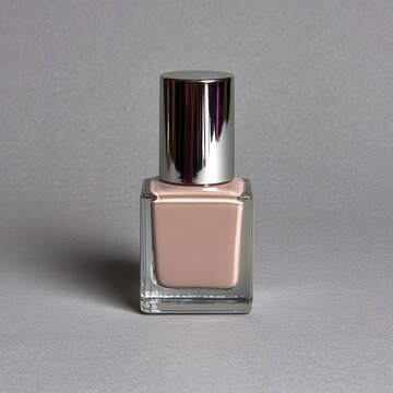 Close up studio shot of a square glass bottle containing light beige nail polish and topped with a metallic silver cap.