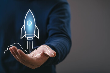 Hand presenting a glowing rocket startup icon, symbolizing business growth, innovation, new beginnings, technology launch, creative ideas, future development, and successful project acceleration.
