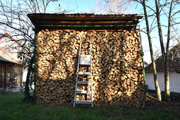 Stacked firewood with a stepladder