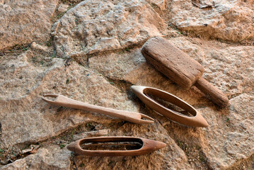 Vintage wooden shuttles and weaving tools on natural stone background