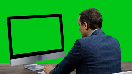 Businessman working on computer with green screen