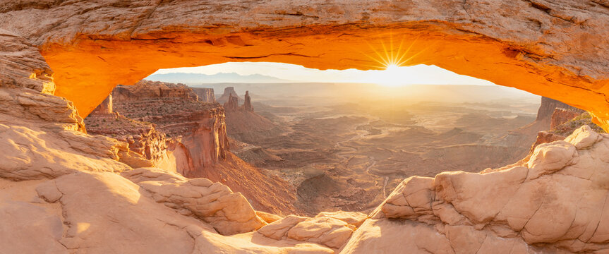 Mesa Arch is a pothole arch on the eastern edge of the Island in the Sky mesa in Canyonlands National Park, San Juan County, Utah, United States. Sunrise in summer time. Popular destination.