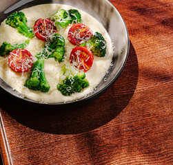Vegetable casserole with broccoli and tomatoes served in a round dish