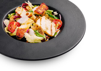 Fresh salad with grilled chicken and nuts served on a dark plate