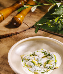 Fresh ravioli dish with creamy sauce and herbs on wooden table