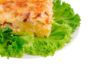Delicious layered casserole with creamy sauce and fresh greens on a plate