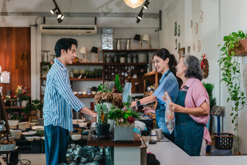 Asian Mother and Daughter Assist Male Customer at Ceramic Shop