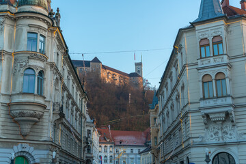 Obraz premium A street perspective in Ljubljana with the Ljubljana Castle rising above historic buildings