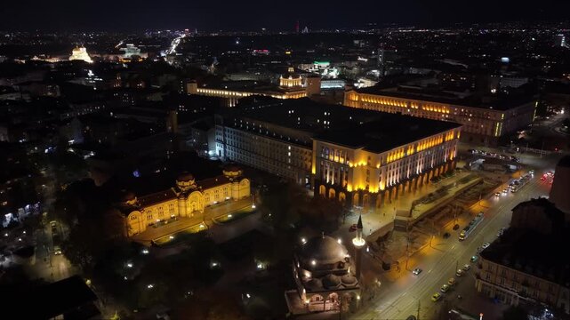 Drone orbits over Sofia&rsquo;s city center at night, capturing glowing streets, illuminated buildings, and the vibrant urban nightscape from above.