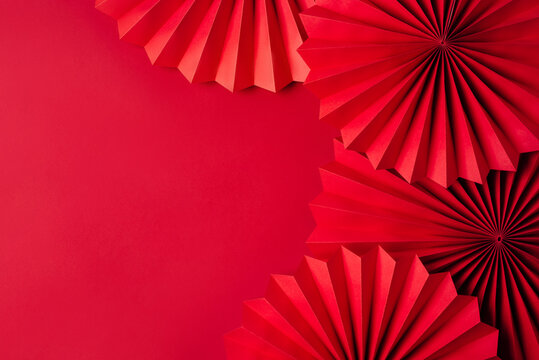 Red paper fans on a red background. Chinese New Year Celebration