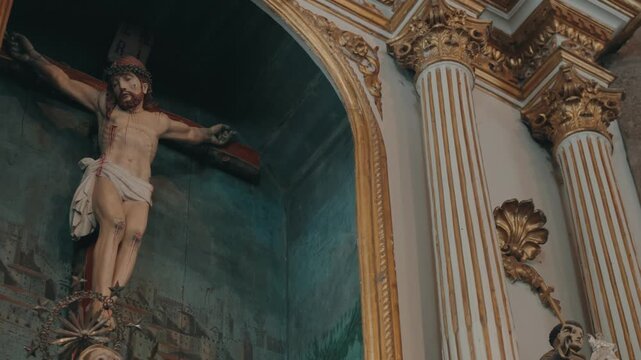 Detailed crucifix sculpture set within an ornate church altar niche