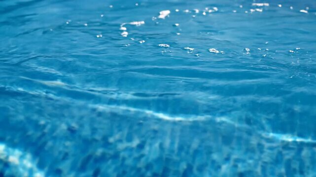 Underwater Serenity Captivating Reflections and Shimmering Light Patterns in a CrystalClear Swimming Pool Perfect for Summer Relaxation and Refreshing Aquatic Adventures.