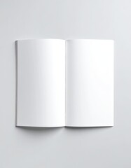 Naklejka premium An open, blank white notebook or magazine mockup lying flat on a light gray surface.
