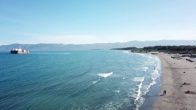 Beautiful sandy beach nestled at the base of the majestic Rif Mountains. Crystal clear Mediterranean waves washing on the shore in Al Hoceima, Morocco.
