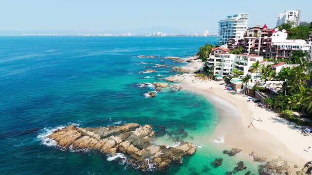 Tropical beach in puerto vallarta mexico with residential buildings and clear ocean. Conchas chinas beach