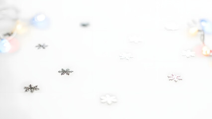 Fototapeta premium Delicate silver snowflakes scattered on a white background