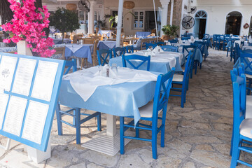 Traditional Greek taverna seating with blue chairs and tablecloths