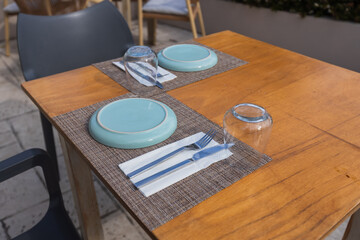 Elegant outdoor table setting with turquoise plates and woven placemats