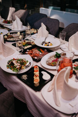 A table set for a banquet or celebration in a restaurant with a variety of dishes