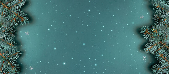 Christmas fir branches on blue background with snowflakes. Merry Christmas and Happy New Year greeting card. Xmas and winter holidays. Christmas banner, top view