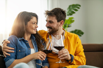 Couple enjoying a cozy evening together with glasses of wine in a bright living room