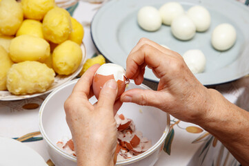 A woman is cracking an egg into a bowl