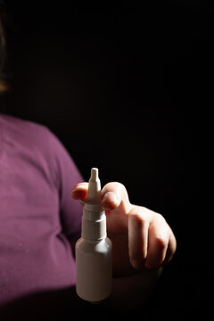 A person holds a vasoconstrictor nasal spray bottle, highlighting its use in rhinitis treatment. Healthcare discussions focus on its effects and potential dependency.
