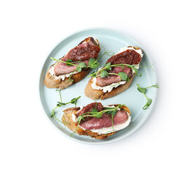 Delicious bruschettas with roast beef, cream cheese, sun-dried tomatoes and microgreens isolated on white, top view