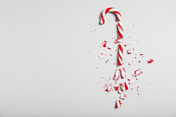 Crushed candy cane on grey background, flat lay with space for text. Christmas treat